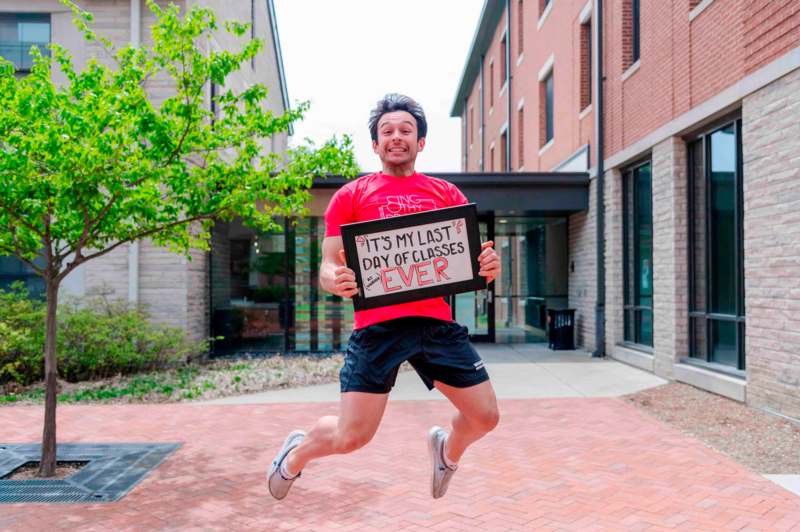 a man jumping in the air holding a sign