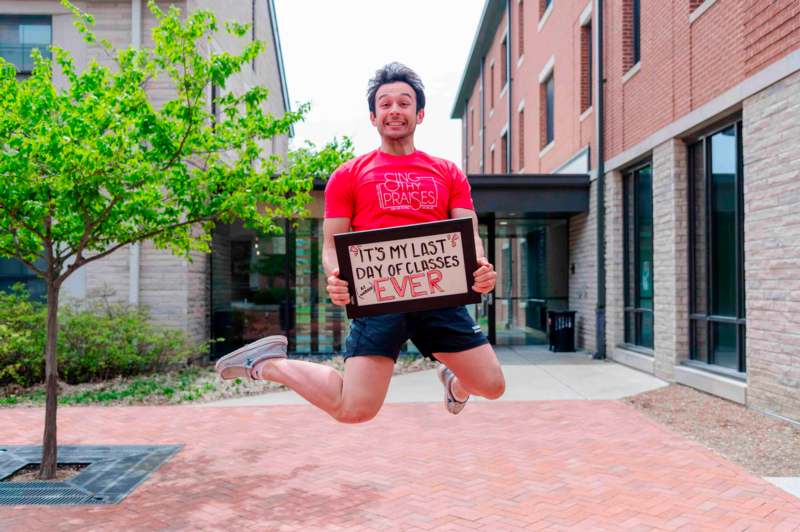 a man jumping in the air holding a sign