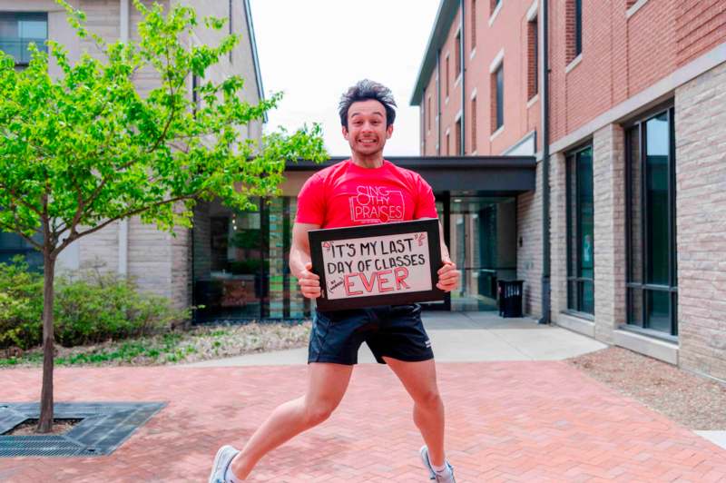 a man jumping in the air holding a sign
