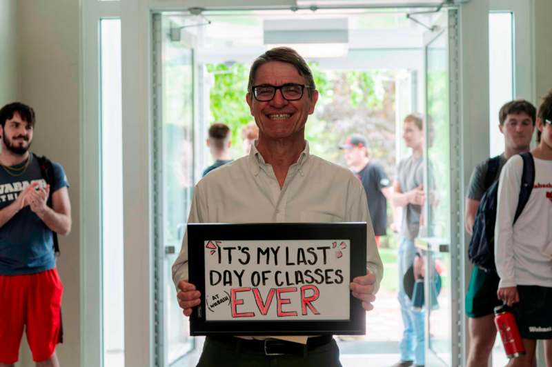 a man holding a sign in front of a door
