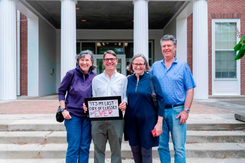 a group of people standing in front of a building holding a sign