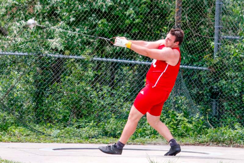 a man in red uniform swinging a rope