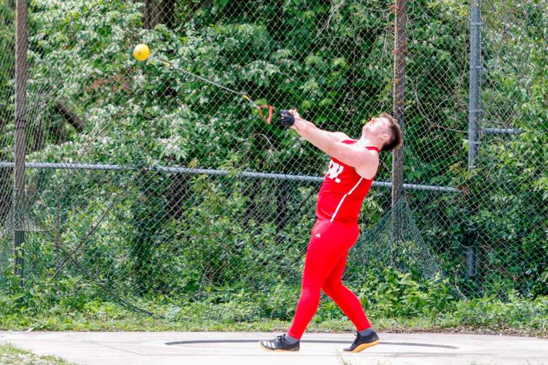 a man in red uniform hitting a ball with a bat