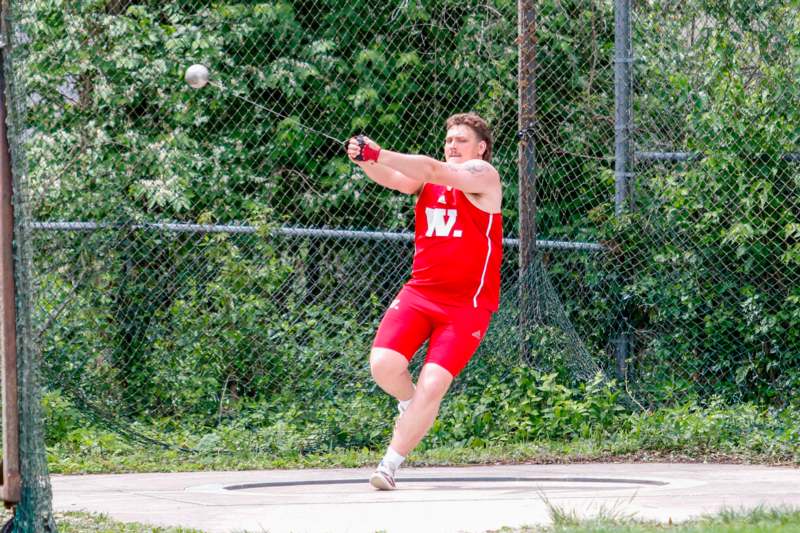 a man in a red uniform hitting a ball