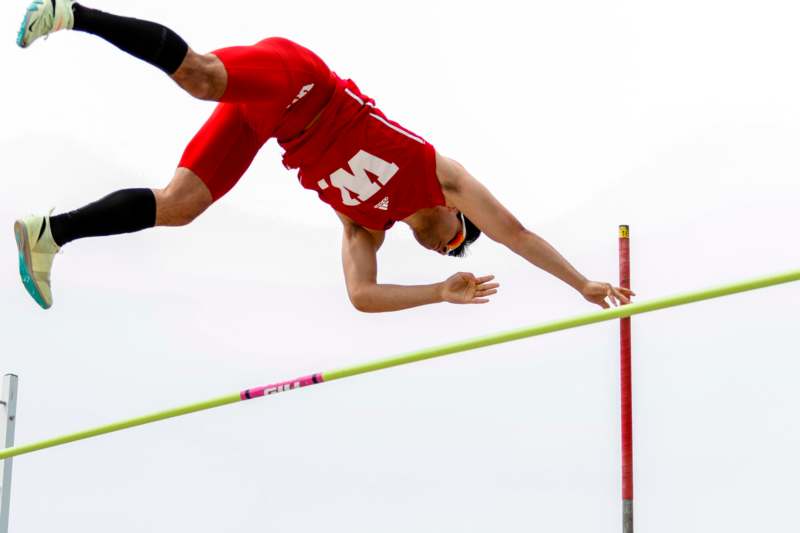 a man jumping over a pole
