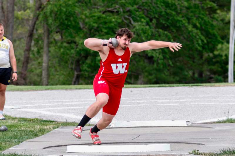 a man in a red uniform throwing a ball
