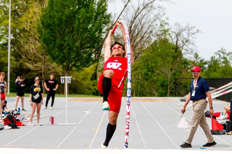 a man jumping over a pole