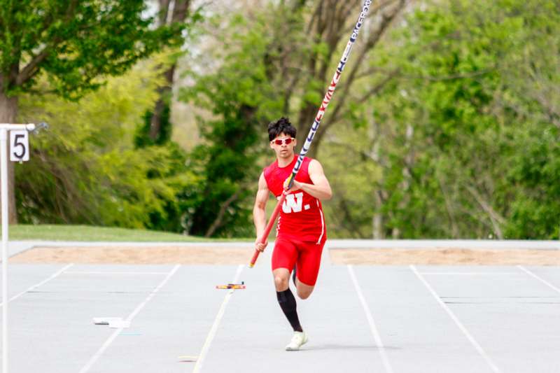 a man in a red uniform holding a pole