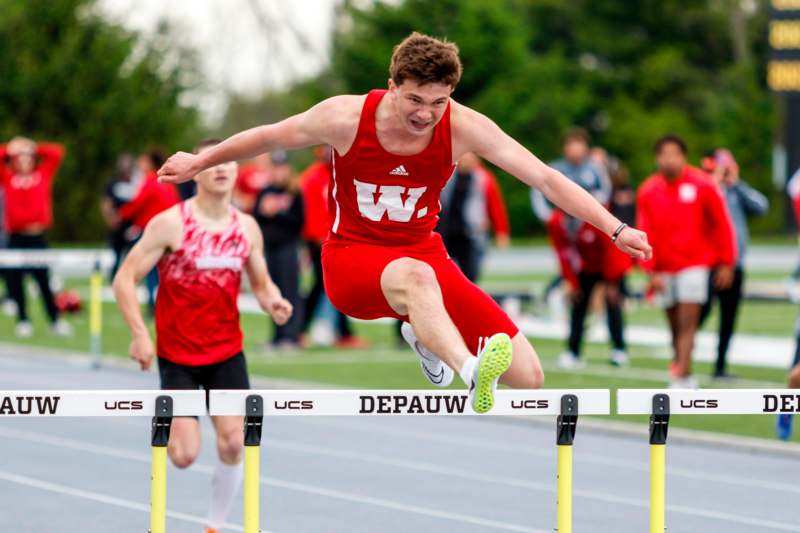 a man jumping over a hurdle
