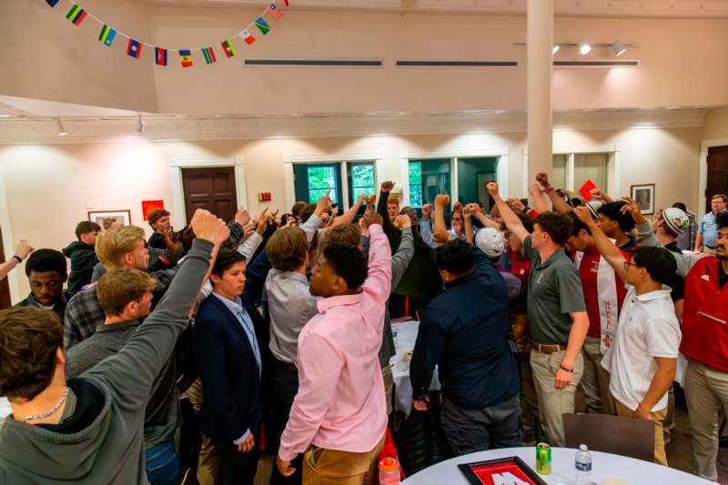 a group of people in a room with a table and flags