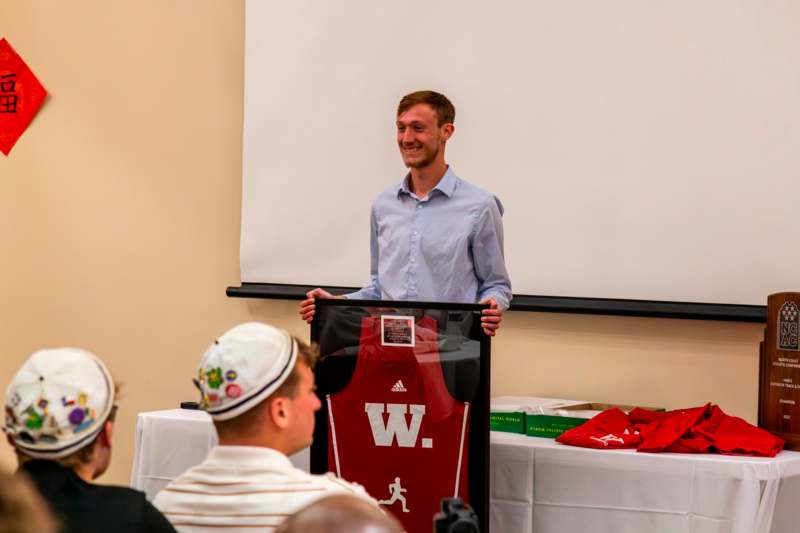 a man holding a framed jersey
