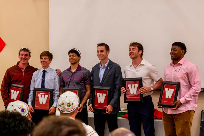 a group of men holding framed pictures