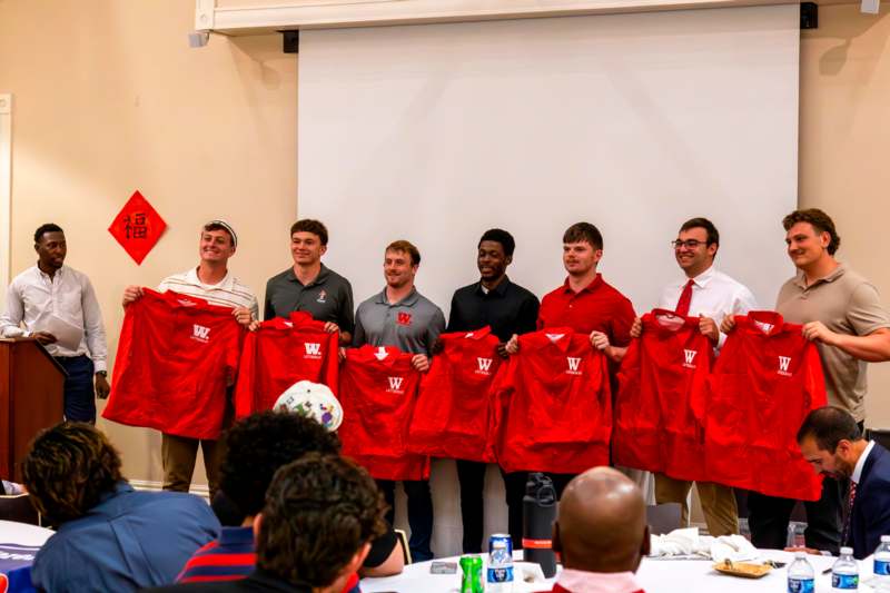 a group of men holding up red shirts