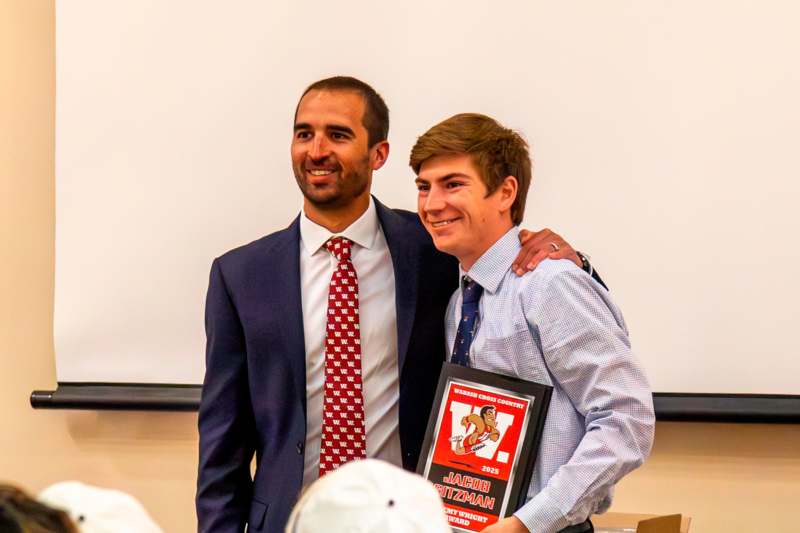 a man in a suit and tie hugging another man in a suit and tie