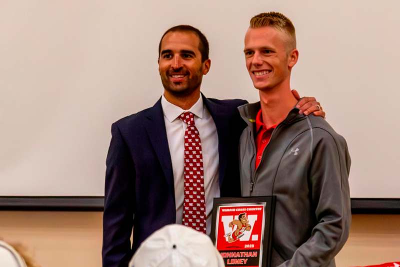 a man standing next to another man