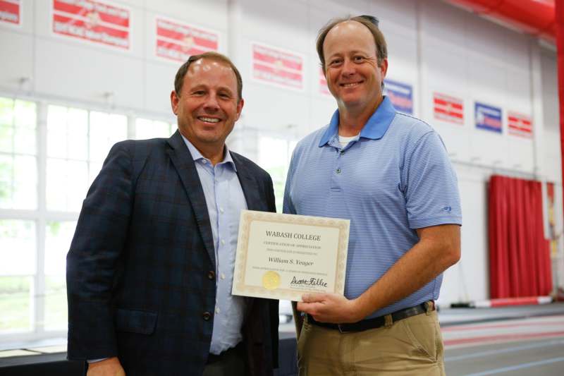 a couple of men holding a certificate