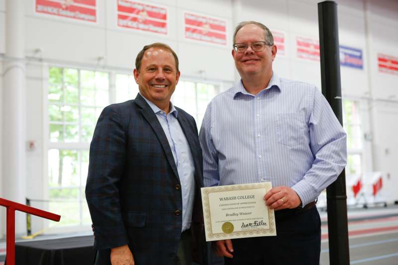 a couple of men holding a certificate