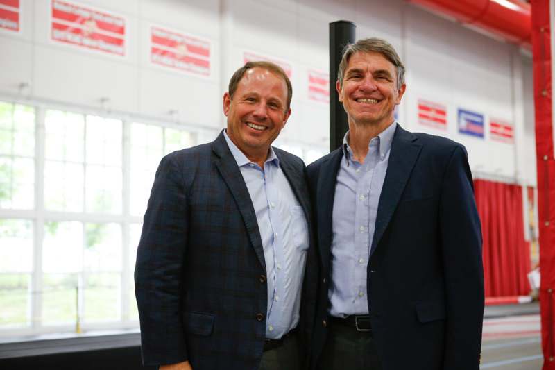 two men standing together smiling