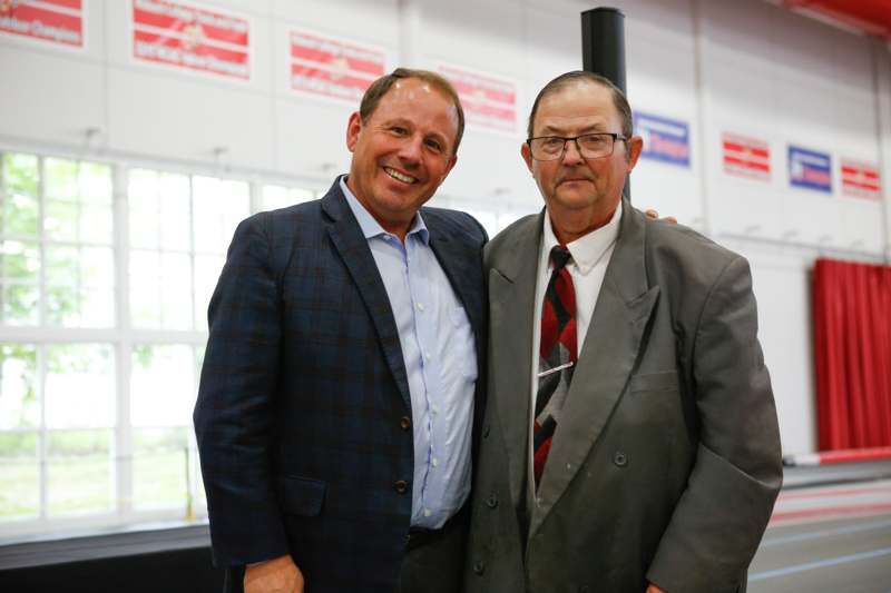two men standing together smiling