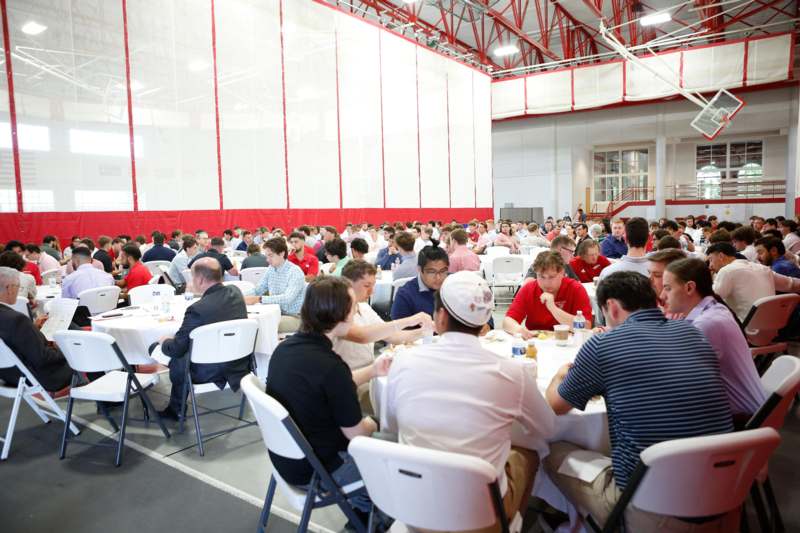 a large group of people sitting at tables in a large room