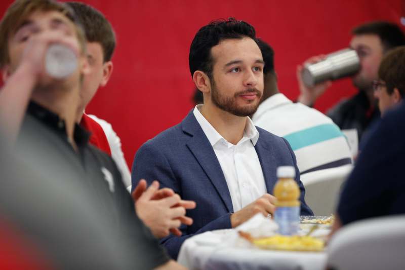 a man sitting at a table with food and drinks