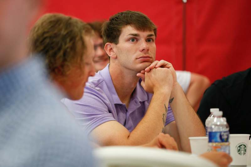 a man sitting at a table with his hands on his chin