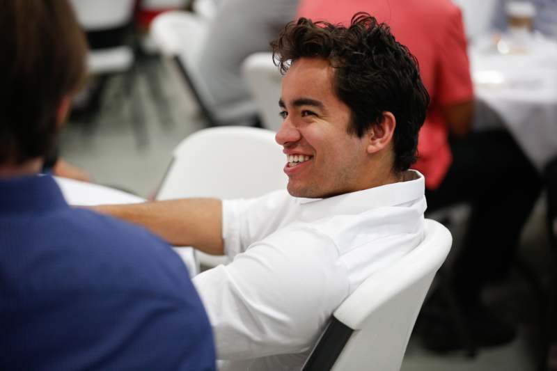 a man in a white shirt smiling