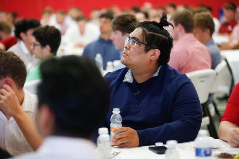 a man sitting at a table with a bottle of water