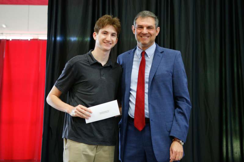 a man in a suit and tie standing next to a man in a suit and tie