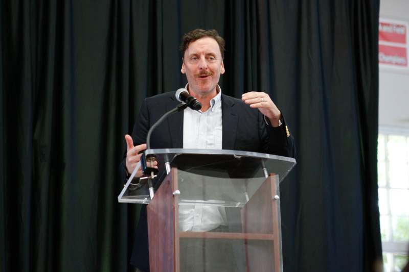 a man standing at a podium with a microphone