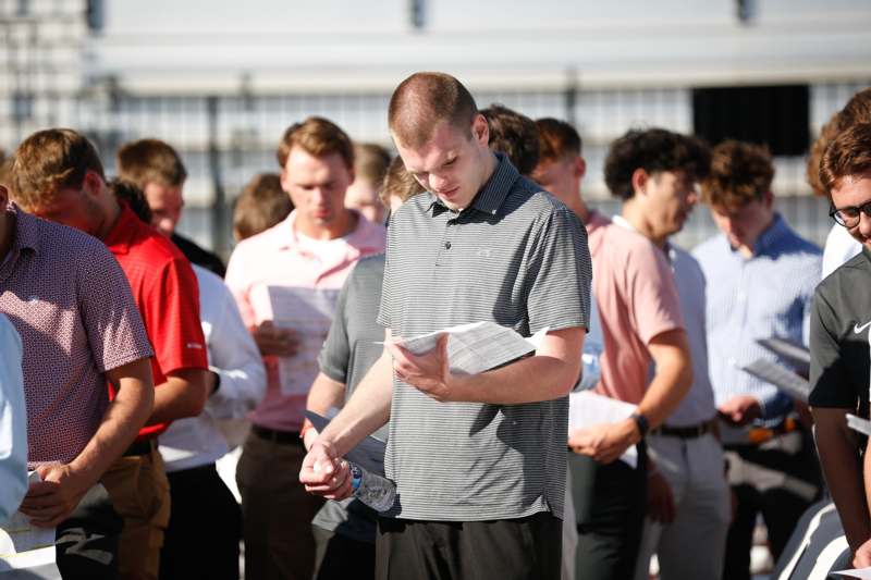 a man holding papers in a crowd
