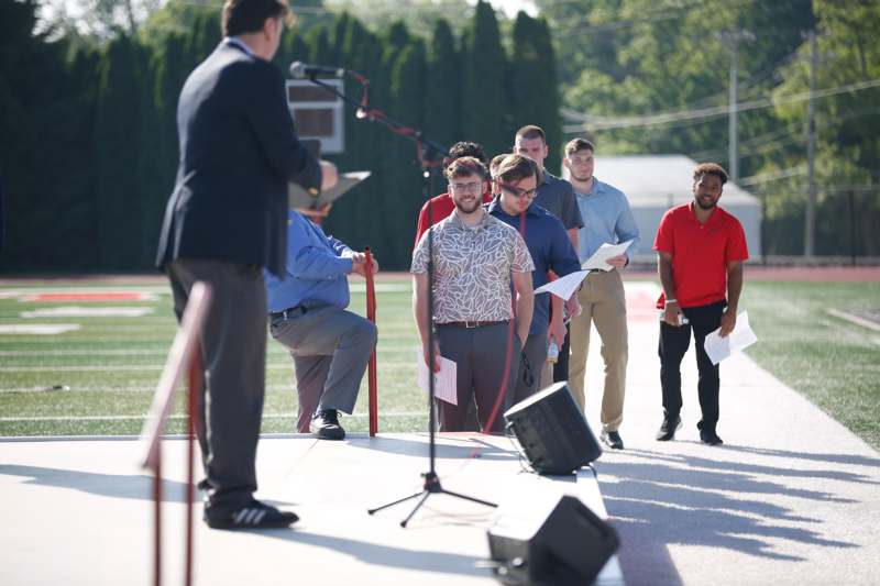 a man standing on a stage with a group of people