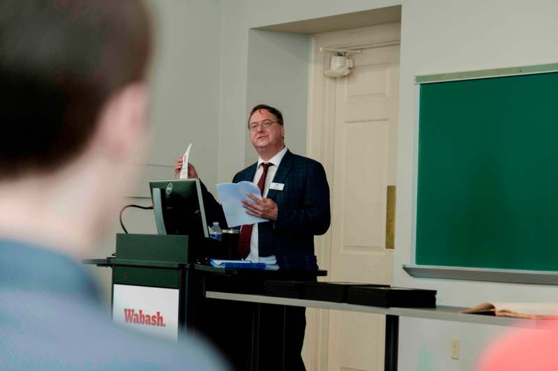 a man standing at a podium with a paper in his hand