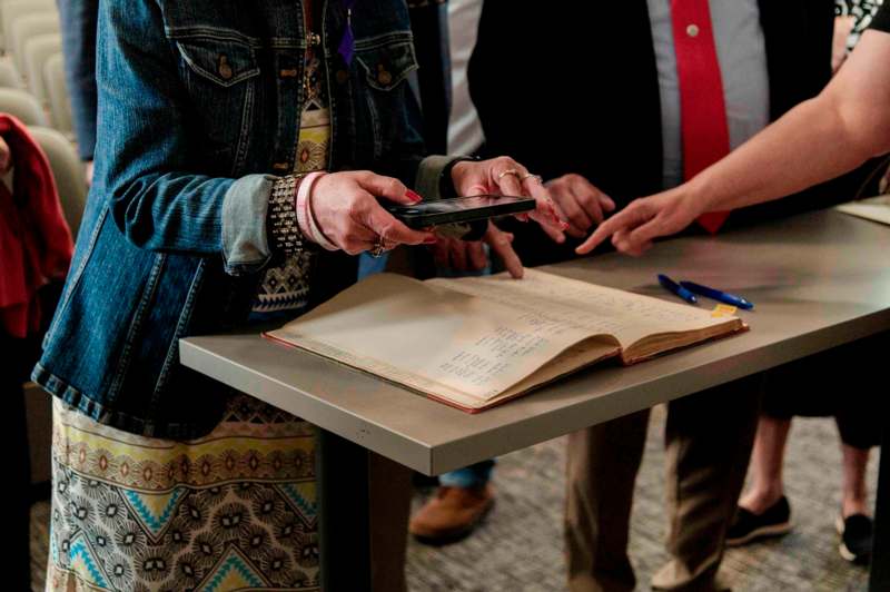 a woman holding a phone over a book