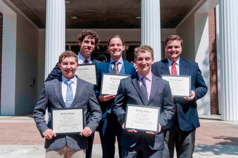 a group of men holding certificates