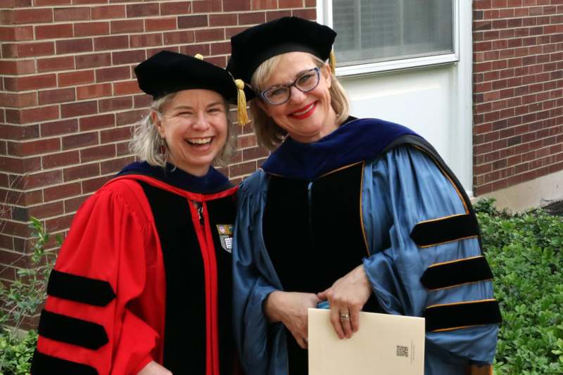 two women in graduation gowns