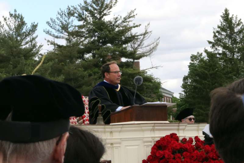 a man in a robe speaking into a microphone
