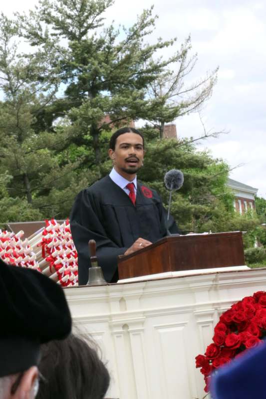 a man in a robe standing at a podium