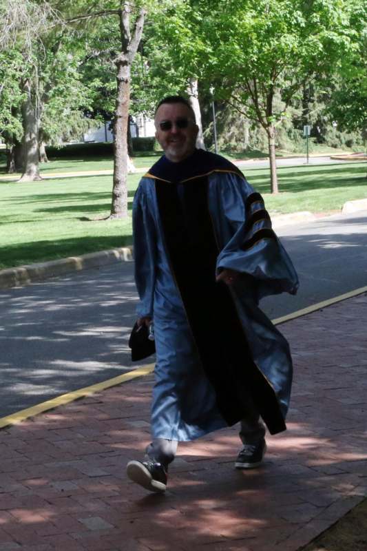 a man wearing a graduation gown and sunglasses