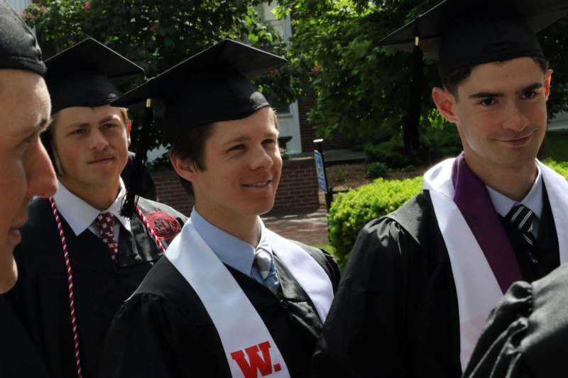 a group of men in graduation gowns and caps