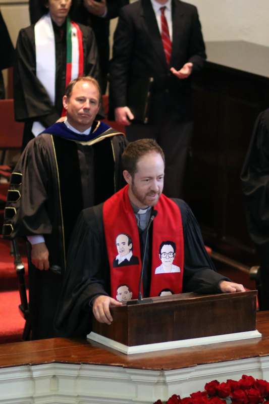 a man wearing a robe and a red scarf