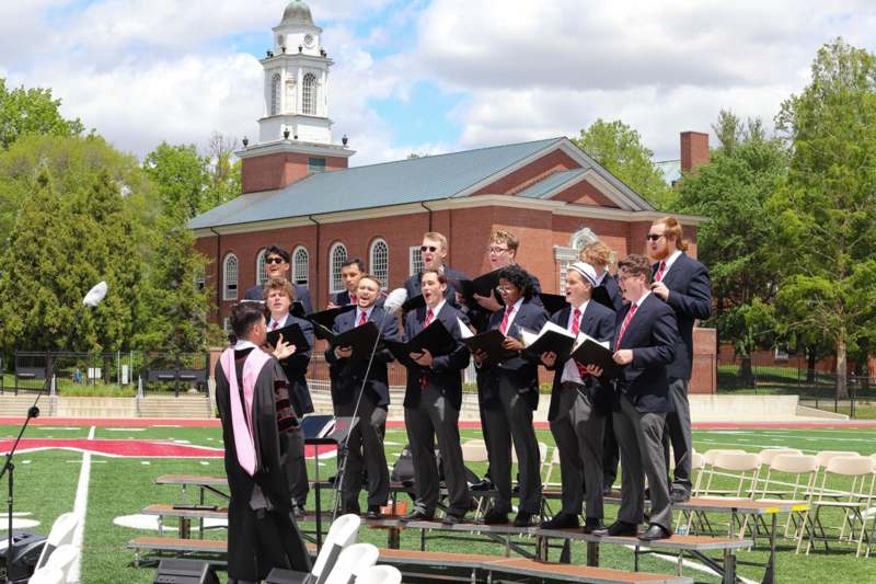 a group of people singing on a stage