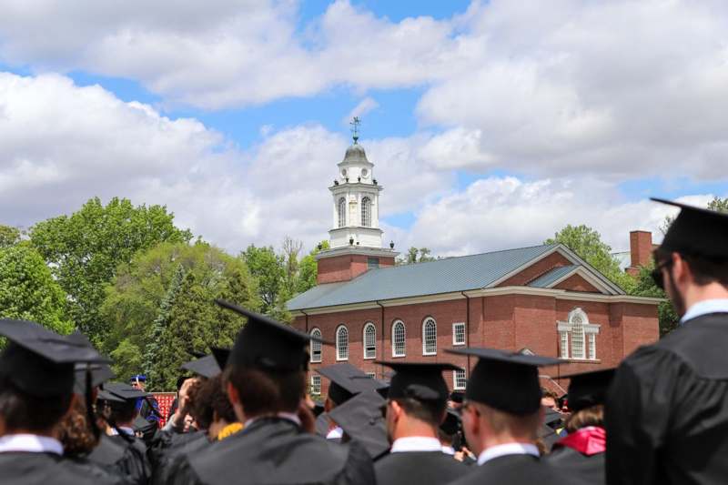 a group of people in graduation gowns and caps outside a building