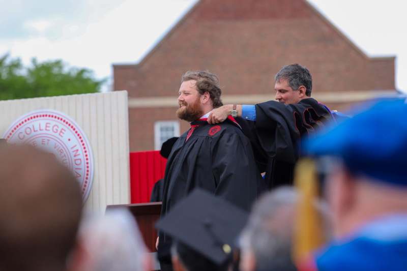 a man putting on a robe on another man