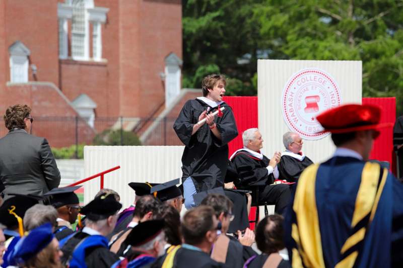 a man in black gown speaking into a microphone