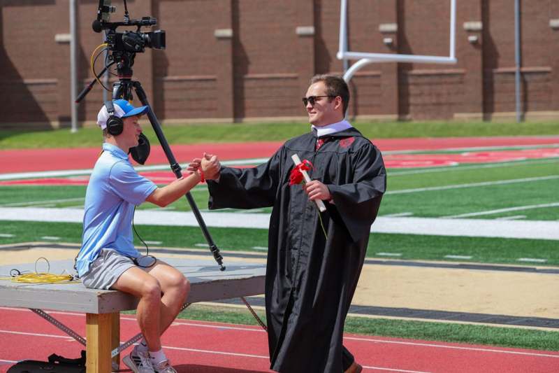 a man shaking hands with a man in a black robe
