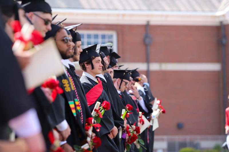 a group of people in graduation gowns and caps