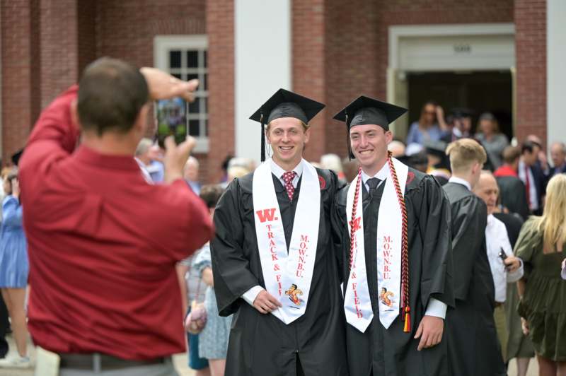 a group of men in graduation gowns and caps