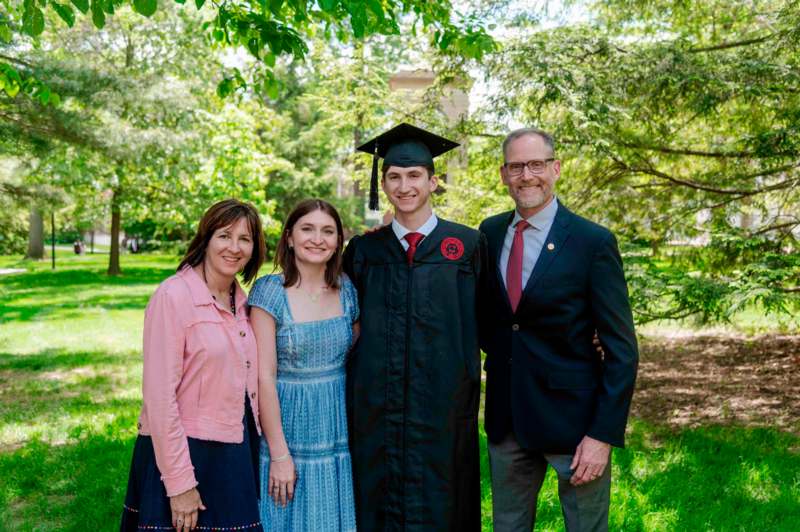a man in a graduation cap and gown with a group of people