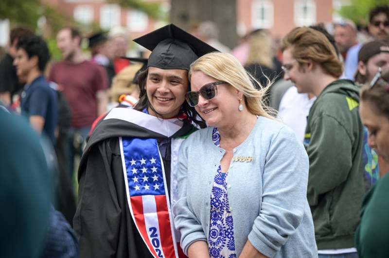 a woman in a cap and gown with a woman in a crowd